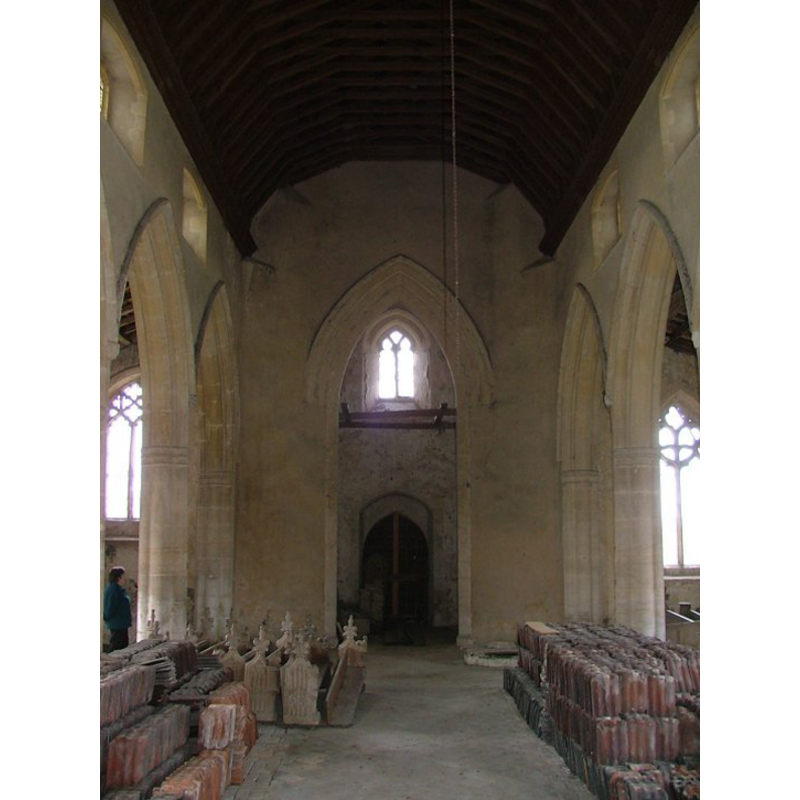 the church interior as photographed in May 2004; the lower base and plinth of the font are partly visible at the far end, behind the rows of tiles, on the north/right side