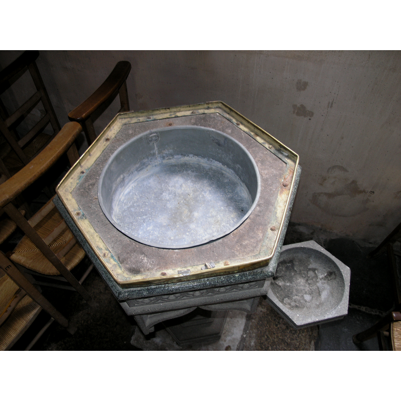 the modern font; the drain whole is in the small basin, and appears to go through the arm or bracket that links it to the main stem