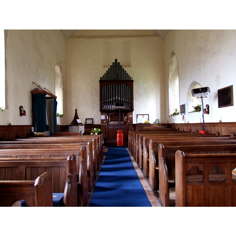 the font and cover at the west end, behind the south bank of pews