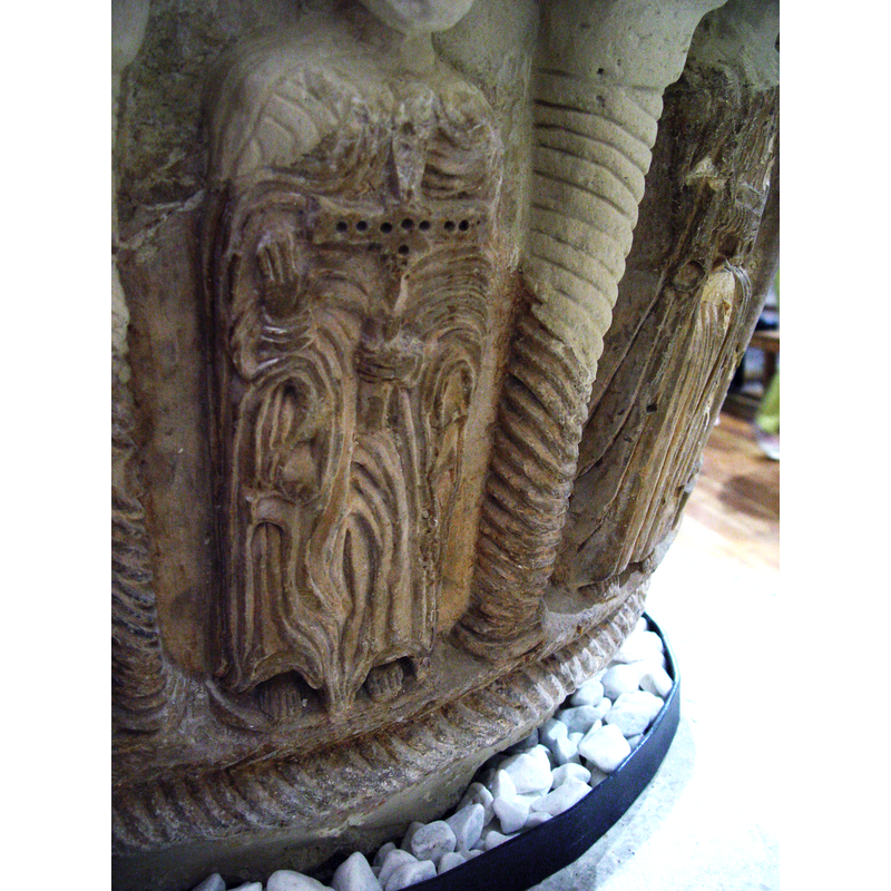 the figure is seated, his right hand resting on the arm of a throne (?); the left hand holds an elaborate processional (?) cross; the vestments are very rich and elaborate -- photographed after the 2008 restoration