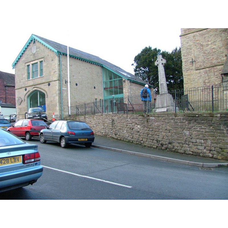 the wall in which the claimed Sheela or Green Man is located, slightly to the right of the back of the blue car