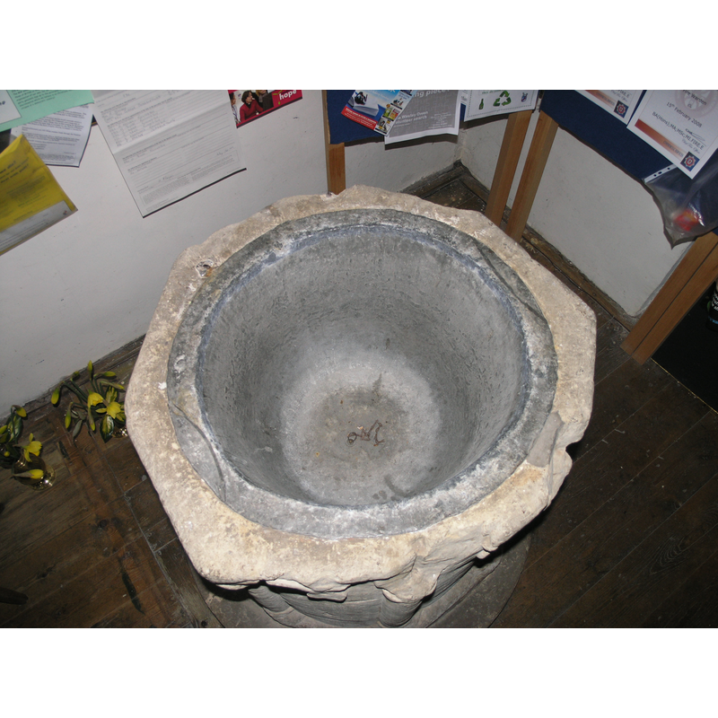 the octagonal shape of the font and the damaged upper rim are clearly visible in this image -