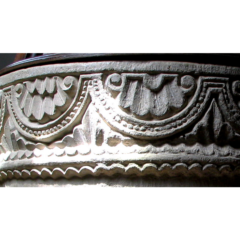 the foliage proper in the spandrels formed by the lunettes; it extends in a scalloped pattern over and under the lower moulding all around the basin
