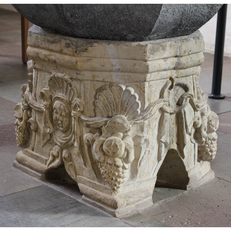 holding up the garland, on two sides of the base