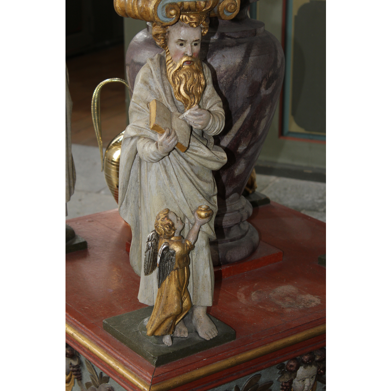 each Evangelist holding a book; accompanied by his symbol in the form of a smaller figure; in this image, Matthew accompanied by a smaller angel, his symbol