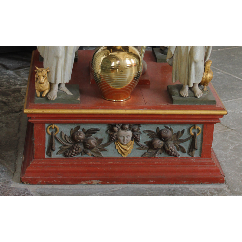 decorated with fruit, garland, etc., on each of the sides of the lower base