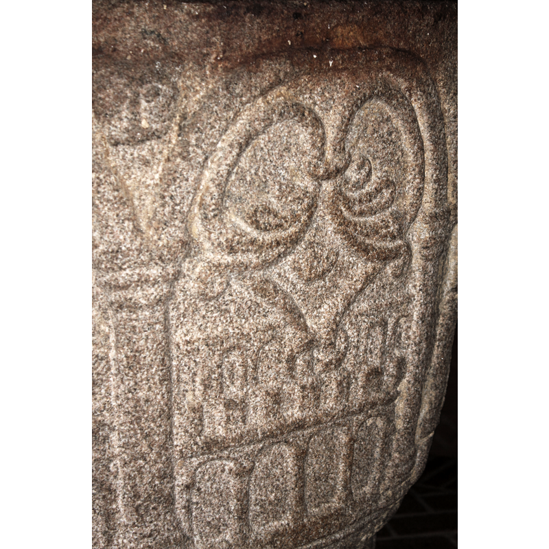inscribed in a round arch; on a row of blank arches or scallops, a row of crenellation and a blind arcade of round arches