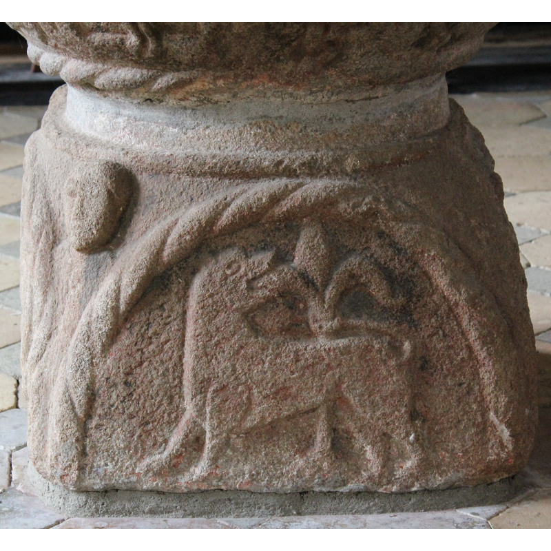on the east side of the quadrangular base; the composition is like the one normally used for the Agnus Dei, but here it is a lion eating a plant instead of the usual lamb and bannered cross
