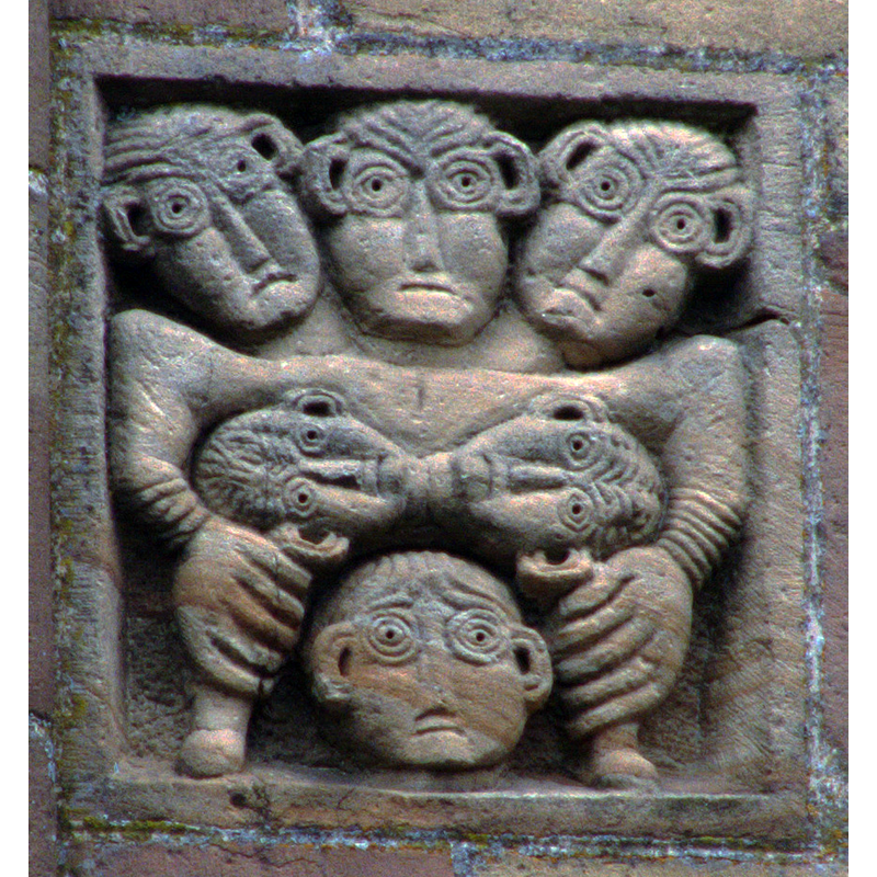 six-head frieze on the façade of the abbey church; resembles the figures on the font from Airennes