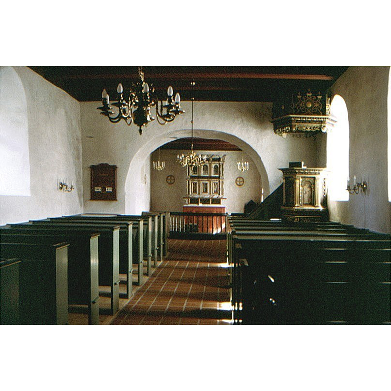 the font is located just east of the chancel arch, behind the bank of pews on the left (north) side