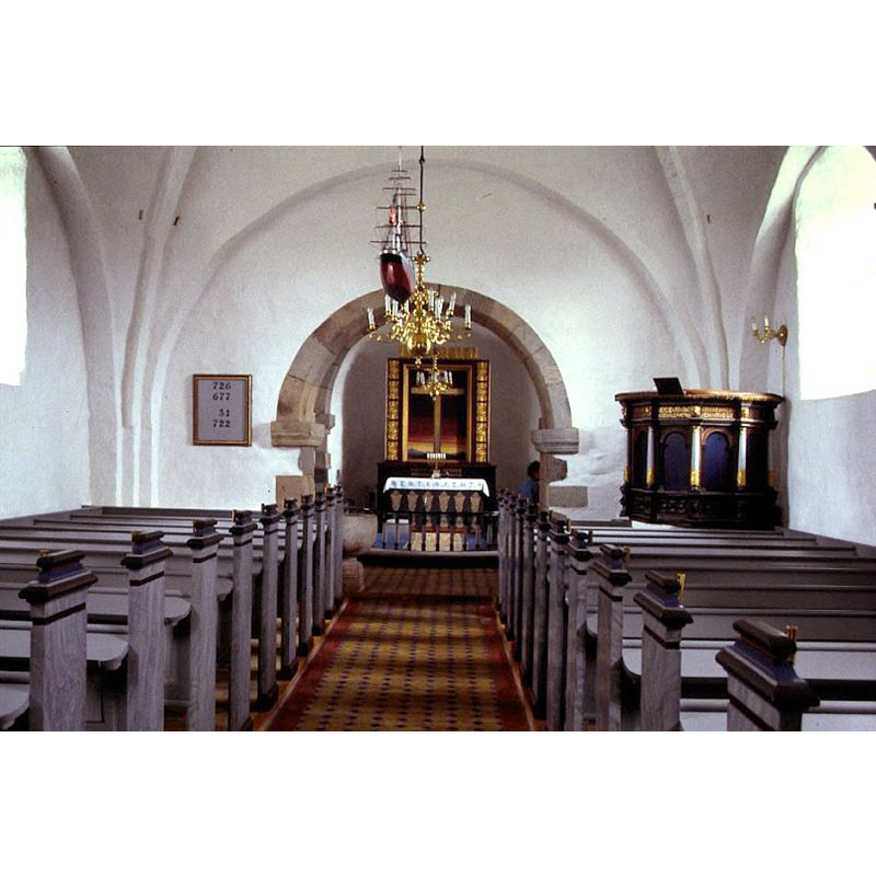 the font is partially visible off the centre aisle, on the left (north) side between the left bank of pews and the chancel arch [probably not its original location]