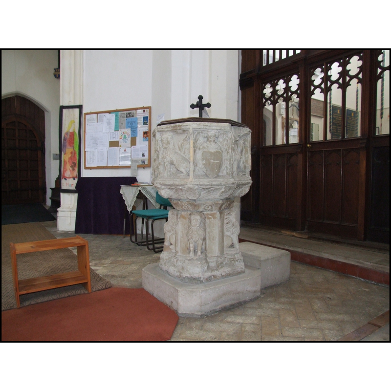 at the west end of the nave; behind it the screen doors to the vestry beneath the tower