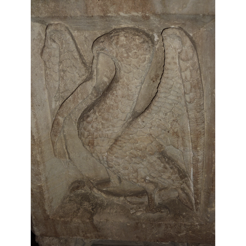 one of four such symbols, alternating with angels holding shields on the sides of the basin; this is on the southeast side