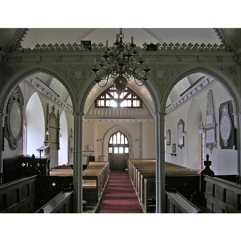 the top of the modern font is visible at the far (west) end, behind the left (south) bank of pews