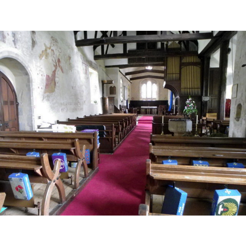 the modern font is visible on the right (south) side, by the south entranceway, between the two banks of pews