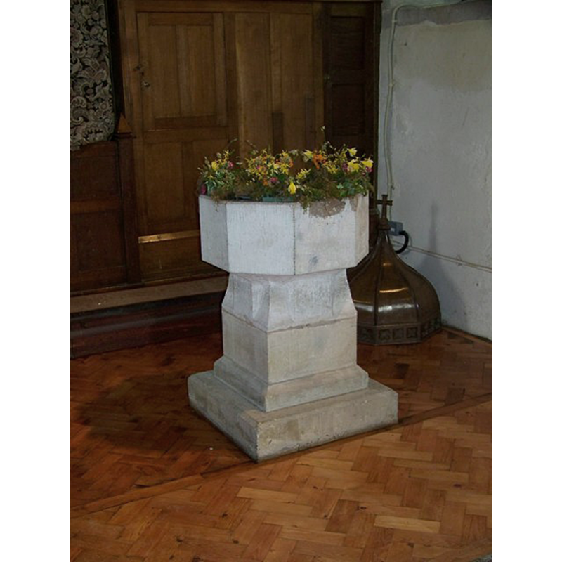 the font cover, an octagonal peaked dome, is visible on the floor, behind the font, in the right corner