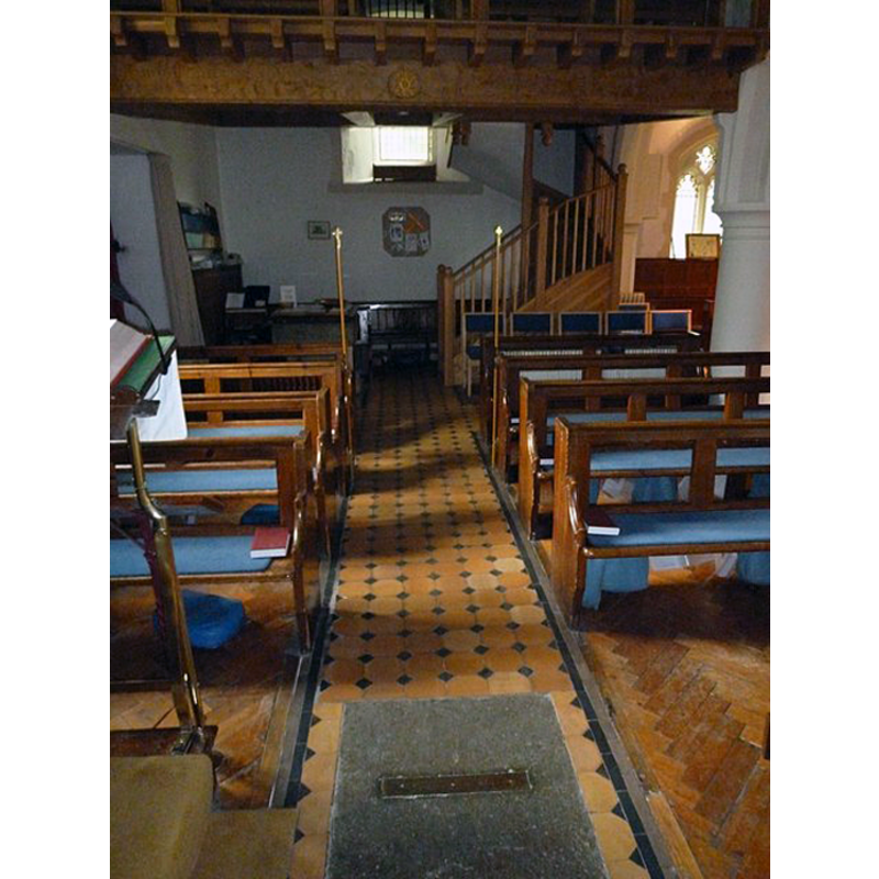 the font partially visible at the west end, south side, opposite the stairs leading up to the gallery