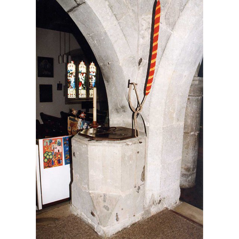 as seen from inside the tower space, looking into the nave; the striped rope ober the font is one of the bell pulls