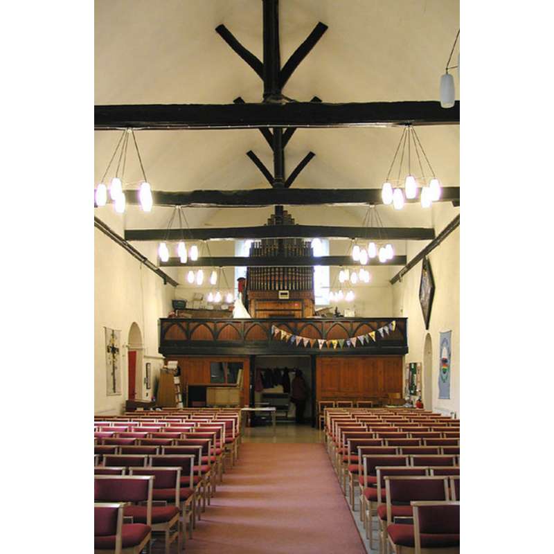 the top of the modern font is visble at the far (west) end, by the south entrance, behind the left (south) bank of chairs