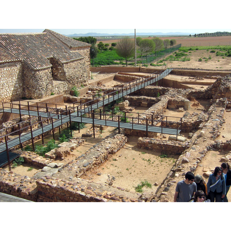 the exterior of the rural chapel on the left, and the excavation site in which the Early Christian baptismal font was discovered