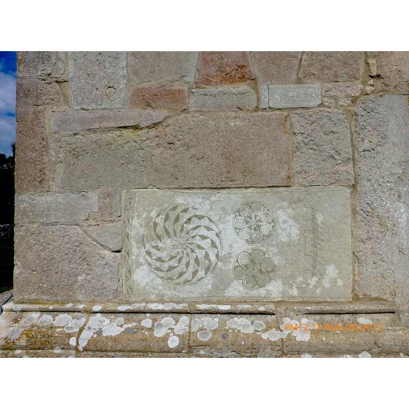 an old stone re-set at the bottom of the tower, south side