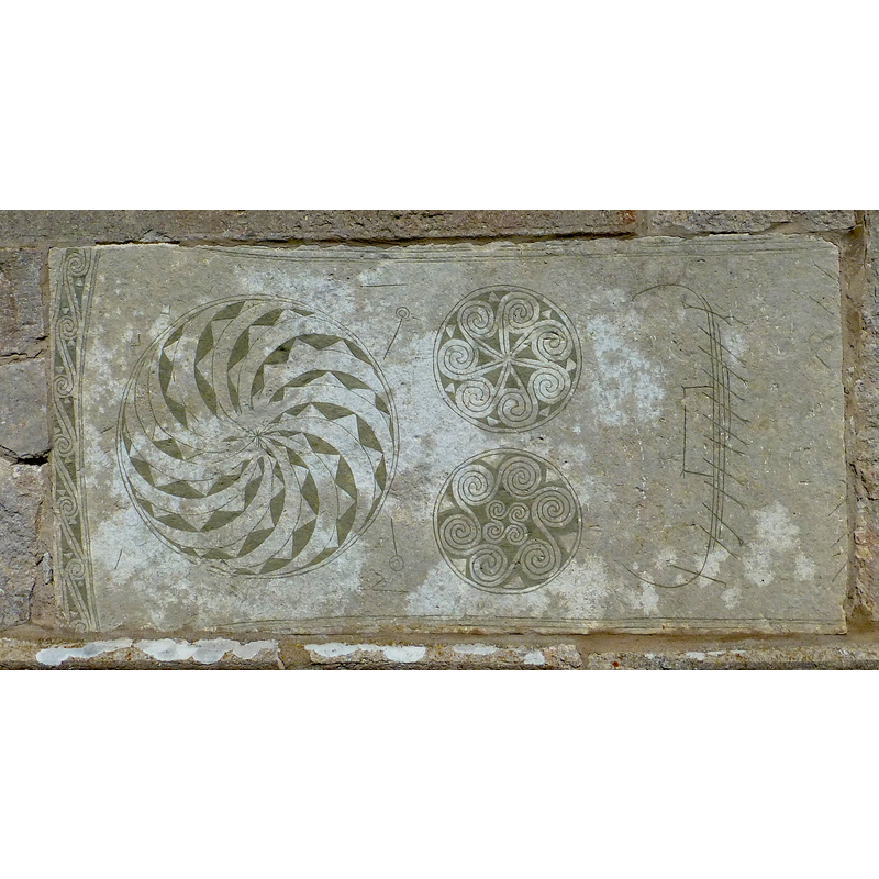 an old stone re-set at the bottom of the tower, south side