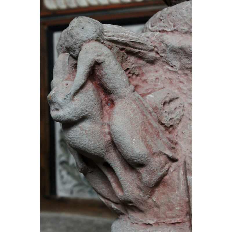 a human riding a lion pulls its head with his hands at the mouth of the beast; long hair on the human head; Samson?