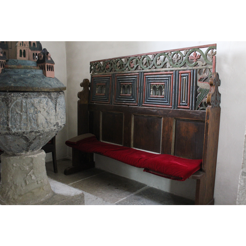 the bench against the north wall of the tower; the old font partially visible on the left