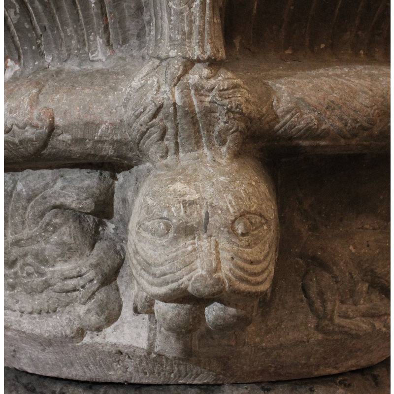 at the feet of the Virgin -- Head of a lion or cat with big fangs and mouth wide open and devours a human of which the only parts visible are the buttocks and legs of the human.