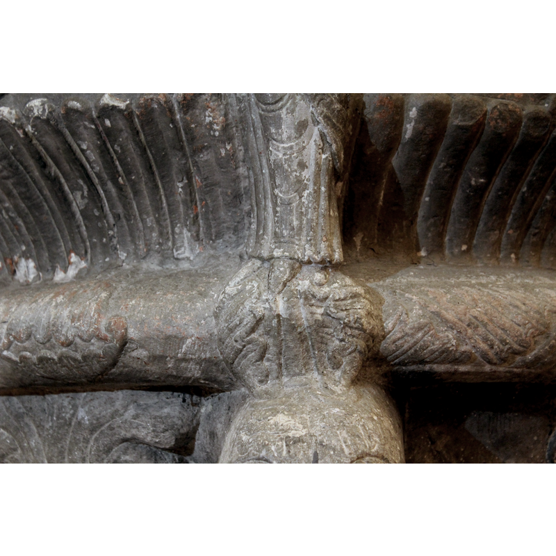 a pair of facing leaves at the feet of Mary, just above the animal head