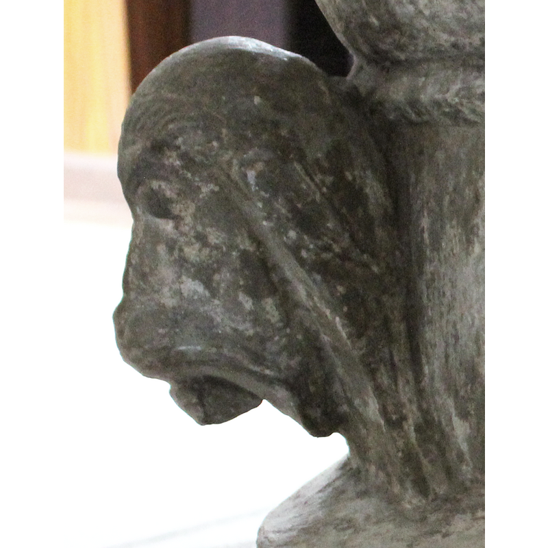 on the southwest side of the base -- right side view -- the face is animal, with long hair and pointed ears, but it wears a hair-band or diadem