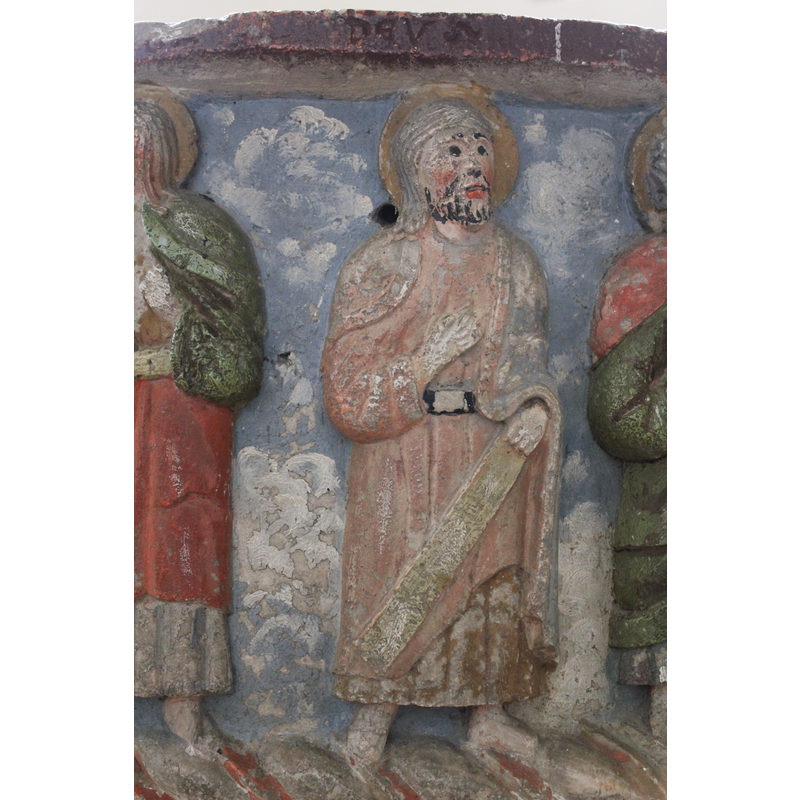 the figure holds a flat board or scroll in his right hand, across the lower part of his body; not one of the usual symbols associated with one of the Twelve