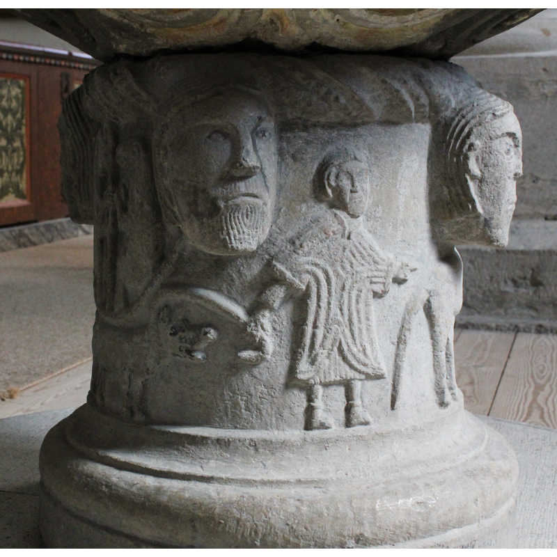 on the southwest side of the base; man wearing a knee-length tunic, passant, to the right, with dog on a leash, also passant