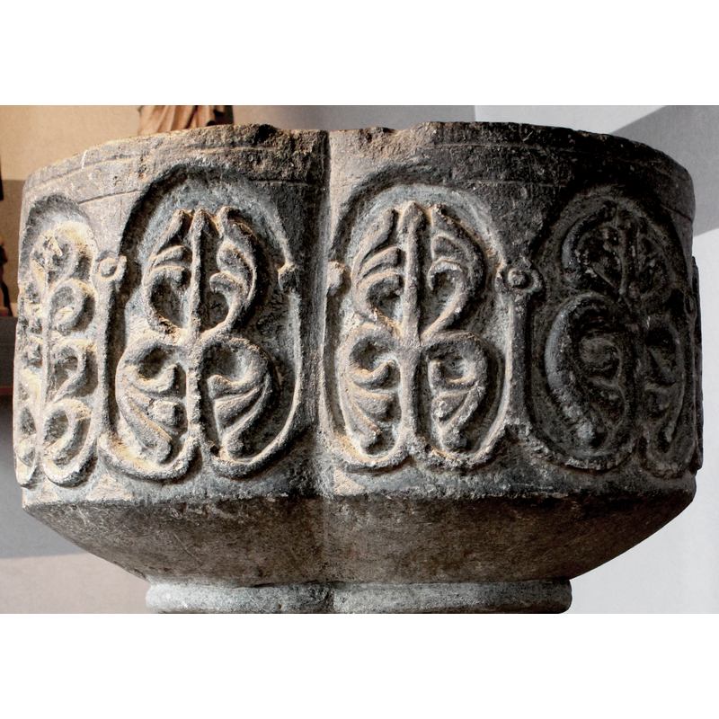 the columns of the arcade have simple capitals but do not have bases; instead, they draw inwards and form part of the motif inside the arch
