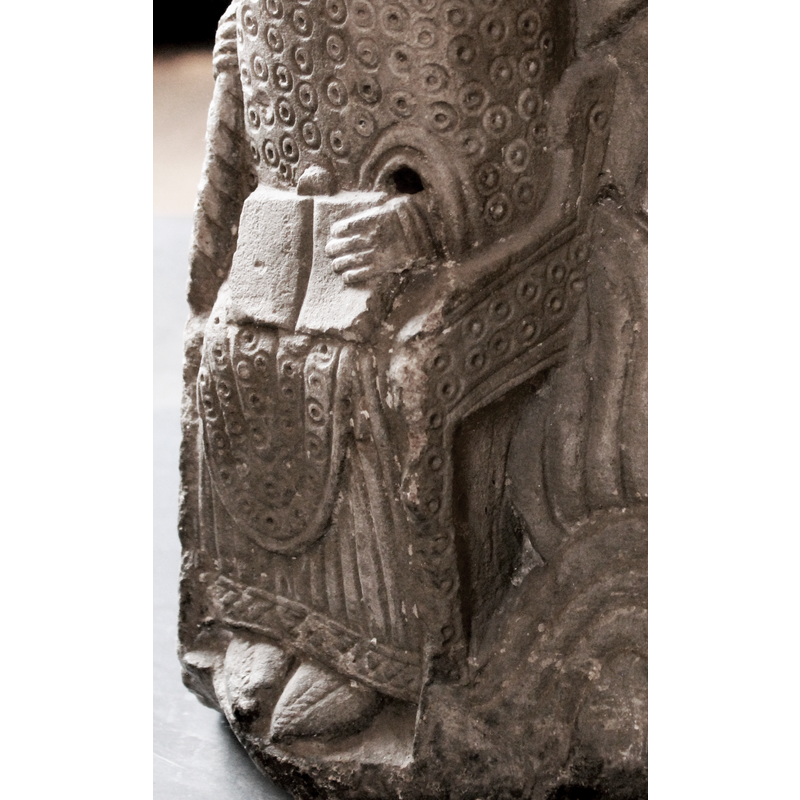although the head and part of the staff or crozier are broken off, the clothes suggest this seated figure is a bishop