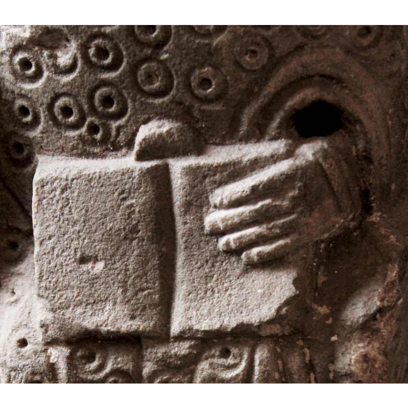 although the head and part of the staff or crozier are broken off, the clothes suggest this seated figure is a bishop