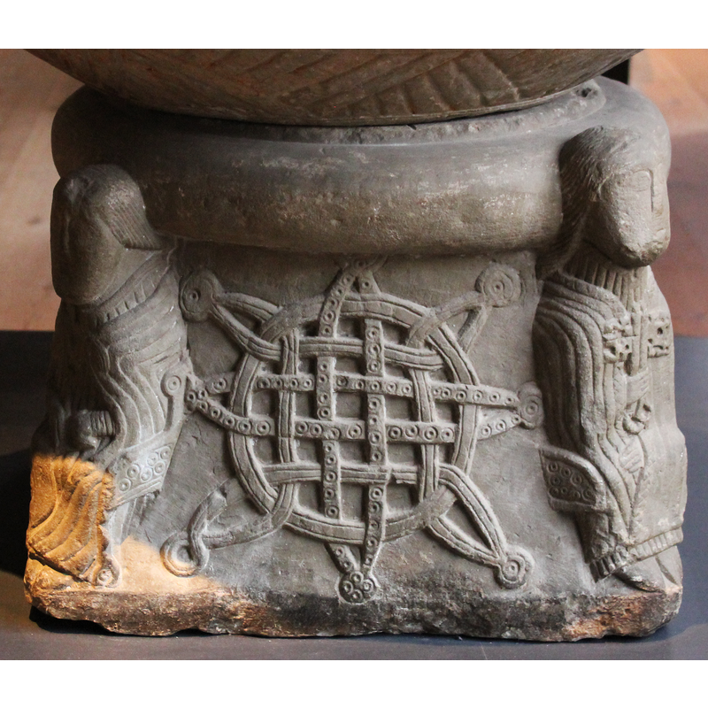 on the side between the cleric (?) holding a scroll on the left and St.Peter on the righ -- some [not all] of the elements have beaded-tape pattern on them; the eight endings have dot-in-a-circle motifs