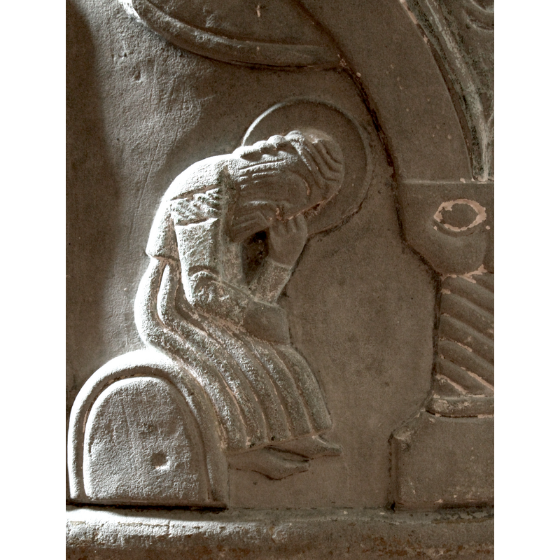 The scene follows the Visitation and shares the same arched arcade. Cloud in upper right corner. Joseph sits beneath the cloud in "Dream Pose". His head is resting on his left hand, eyes closed and his right hand rests on his lap. He is bearded and haloed. He wears a robe tied at waist.