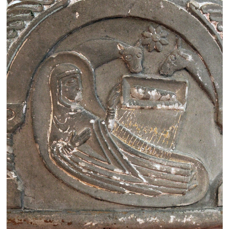 Joseph is absent from this scene. Mary lies on a kidney-shaped couch, the infant in swaddling clothes in a plain rectangular manger above her; animals in attendance: ox on the lfet, mule on the right; star shaped like an eight-petalled flower above, between the two animals; rays project from the manger onto Mary. The rays of light radiating from the Child are incised lines which cross over the edge of the manger to  the edge of Mary's bed and unto her body. Mary 's left hand is extended toward the Child