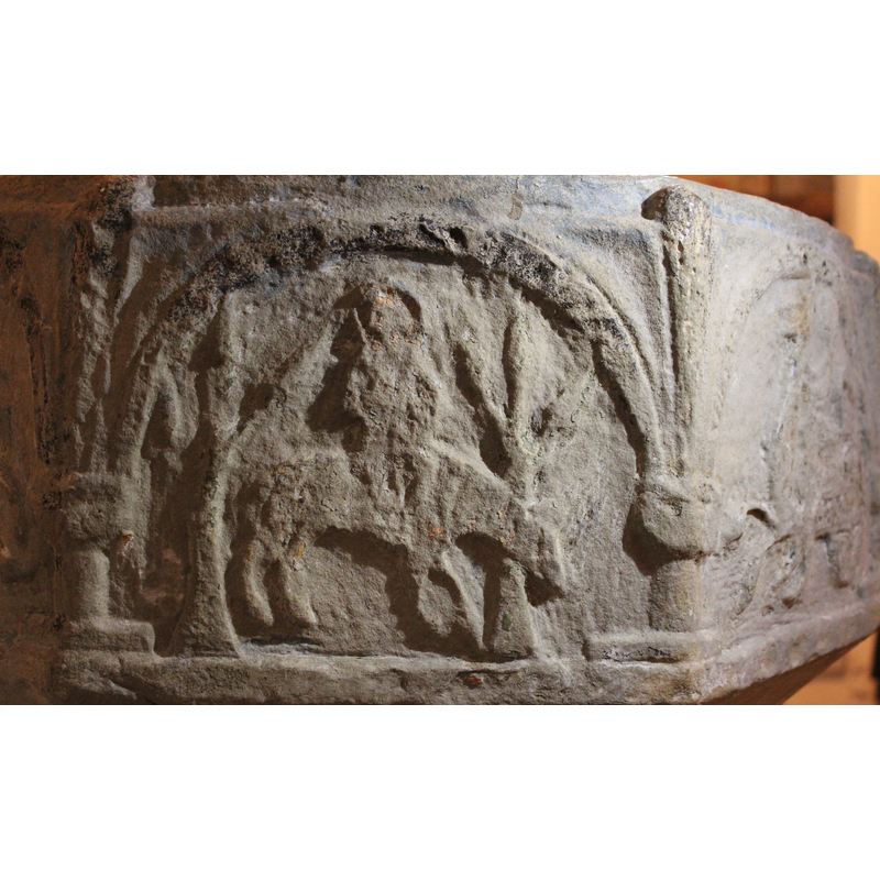 on the northeast side of the basin -- a haloed figure riding a quadruped between two acanthus trees.  This is interpreted as Christ's triumphal entrance into Jerusalem in Sveriges kyrkor [cf. FontNotes]