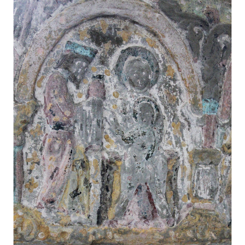 the Adoration of Magi scene occupies two arches. This arch includes Madonna and Child enthroned, frontal posture with child on lap. Throne is worn but might have had animal heads on either side. Christ child points to the first approaching king and holds something in his left hand. Both Virgin and Child are haloed and she wears a habit-like head gear (no evidence of braids). The first king approaches the seated Madonna from left (she is seated on the right side of the composition). The Magus is wearing a crown  (Byzantine headwear? Type) has stooped head and walks in profile. He is wearing long robes. His hands, covered in a cloth, offer a gift.The second arch of this scene includes the remaining two kings, walking in profile toward the right, holding a round container with knob on top, on hands covered with cloth. They too are crowned in similar types of crowns as the first king. There are no other features evident in this scene. [NB: narrative program proceeds from the right to the left].