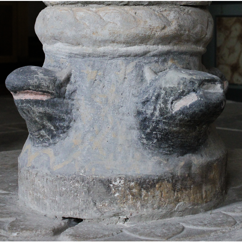 on the east side of the base [orientation is approximate] -- Eared or horned beast? Like the other three heads, now very eroded and painted over, which makes identification difficult