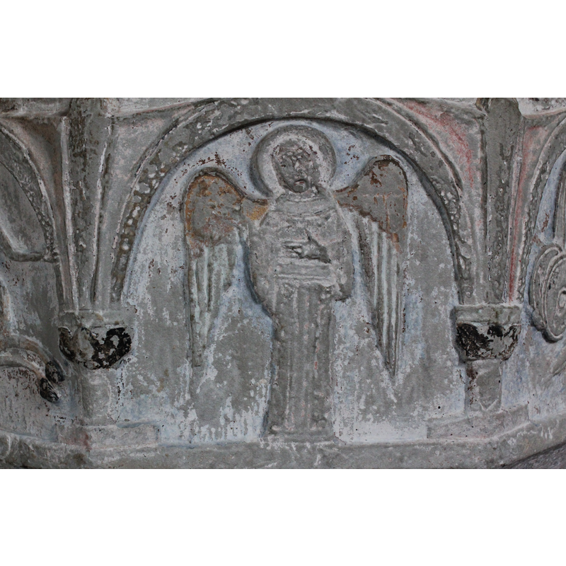 on the south side of the basin [orientation is approximate] -- a haloed angel stands full front, wings open, right hand raised in benediction gesture; the left hand also in the benediction gesture is across its lower chest.