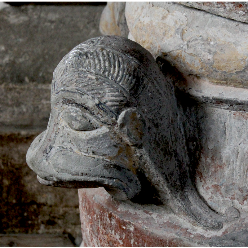on the southeast side of the base [orientation is approximate] -- right side view; identification is tentative, as this head has a certain simian character as well