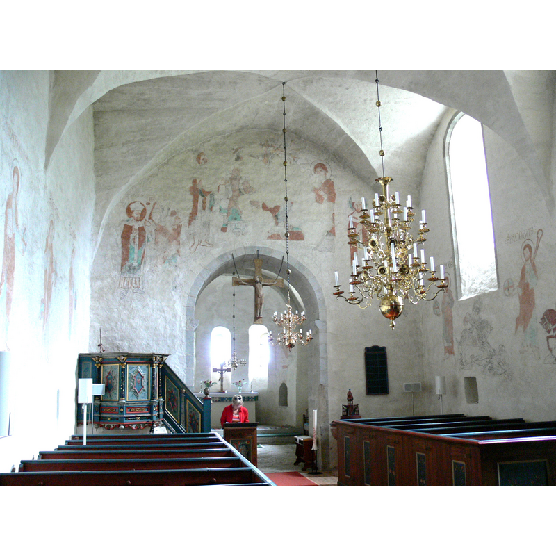 the 13th-century reredos habging from the chancel arch -- on the left is the 18th-century pulpit [not the usual location] -- on the right, showing above the bank of benches of the south side, is the font cover [not its original location]