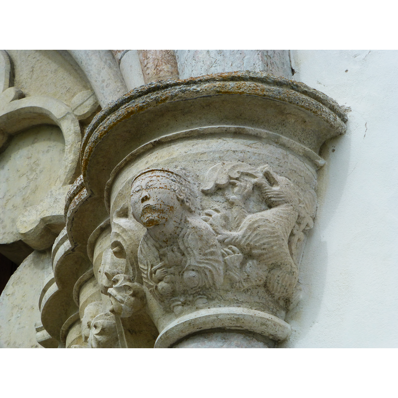 opening into the west end of the nave -- a seated/crouching figure on the left appears to hold a cross in his hands; to the right, a rampant lion with long acanthus-like tongue