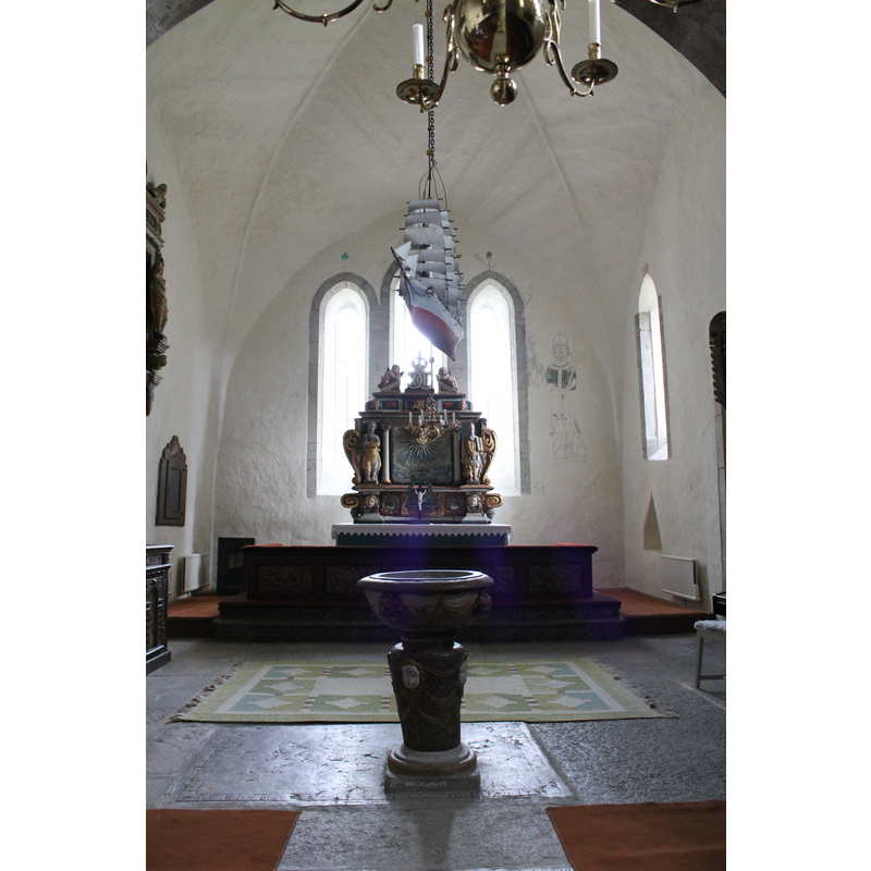 the 17th-century font beneath the chancel arch