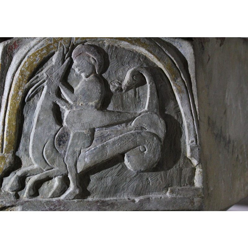 on the southwest side of the basin [orientation is approximate] -- the beast's body with double-coiled tail faces to the left with a man riding on it. Itss head is turned back and up. The man holds it by the neck.