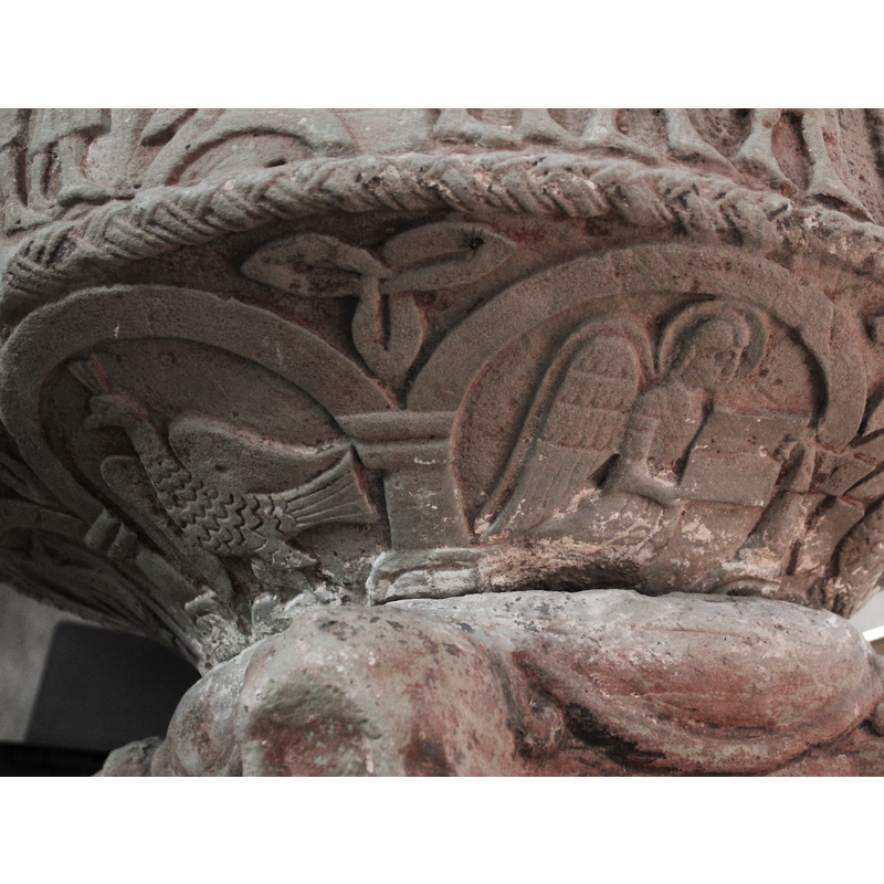 very worn; the bodies of serpents wrapping under it