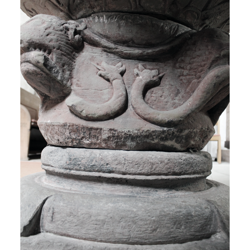 the bodies of the snakes thread their way above the lion heads; two heads appear on the south side of the base